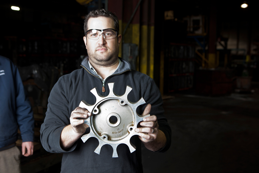 An employee holding steel product, one of the reasons customers prefer LeClaire Manufacturing. 